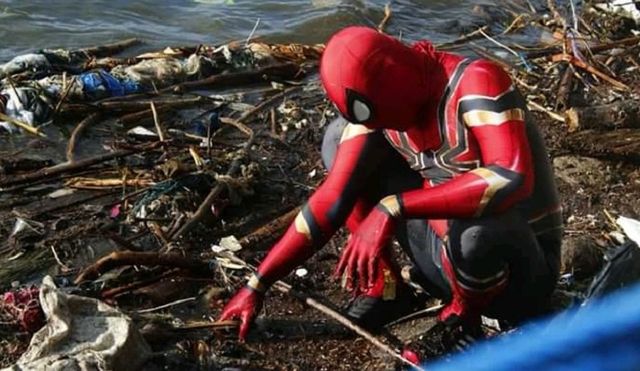 Spiderman asal Parepare saat memungut sampah plastik di pinggiran pantai, (Makassar Indeks/Ardi).