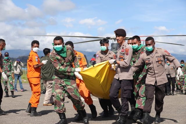 Personil Polsek Pegunungan Bintang dalam proses evakuasi 12 jenazah korban helikopter MI 17 di Bandara Oksibil. (Dok: Polda Papua)