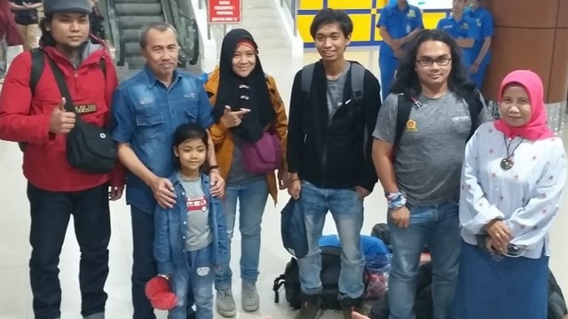 GUBERNUR Riau, Syamsuar, saat memegang pundak anak perempuan diapit kedua orangtuanya saat mendarat di Bandara Sultan Syarif Kasim II, Sabtu malam, 15 Februari 2020. Turut mendampingi Kadis Kesehatan, Mimi Yuliani Nazir. 