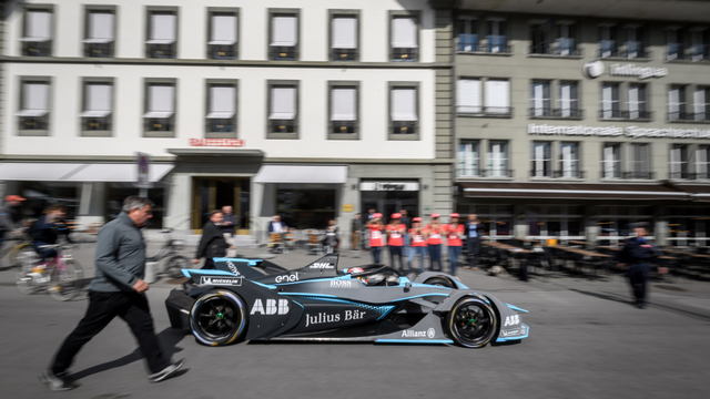 Swiss Sebastien Buemi mengendarai mobilnya di depan Gedung Parlemen Swiss saat promosi kejuaraan mobil listrik Formula E di Swiss. Foto: Fabrice COFFRINI / AFP