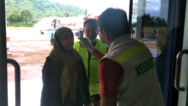 Petugas karantina kesehatan Bandara Sultan Bantilan Tolitoli, Sulteng, memeriksa kondisi suhu badan Julita saat berada di pintu ruang kedatangan, Minggu (16/2). Foto: Istimewa