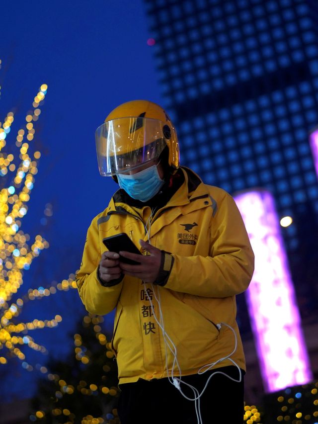 Pengantar paket menggunakan masker akibat virus corona di Beijing, China. Foto: REUTERS/Stringer