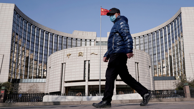 Seorang warga berjalan menggunakan masker akibat virus corona di distrik pusat bisnis Beijing, China. Foto: REUTERS/Jason Lee