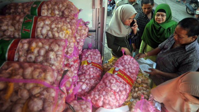 Warga membeli bawang putih saat operasi pasar di kawasan Pasar Raya, Padang. Foto: ANTARA FOTO/Iggoy el Fitra