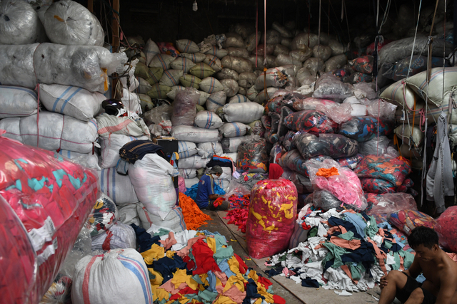 Pekerja memilah limbah sisa kain di tempat pengepul limbah tekstil, Jakarta. Foto: ANTARA FOTO/Muhammad Adimaja