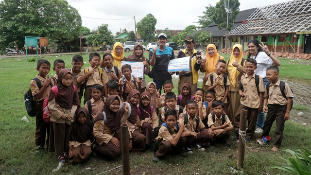 Penyerahan donasi kumparanDerma ke SDN Samudrajaya 04. Monos (berbaju biru di tengah), pendamping proyek renovasi dari Sekolah Relawan, turut hadir dalam penyerahan donasi. Foto: Iqbal Firdaus/kumparan 