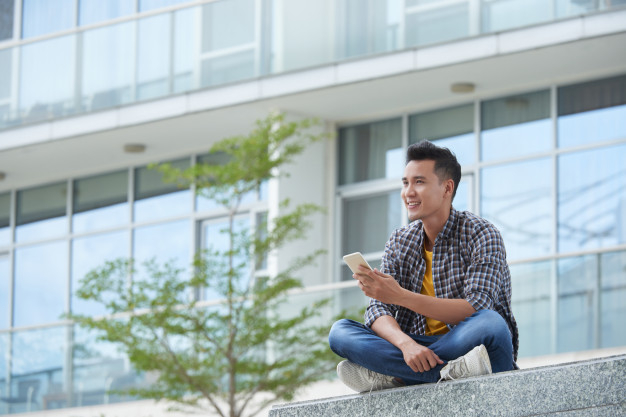 asian-student-sitting-campus-stairs-outdoors-with-smartphone-staring-distance_1098-19282.jpg