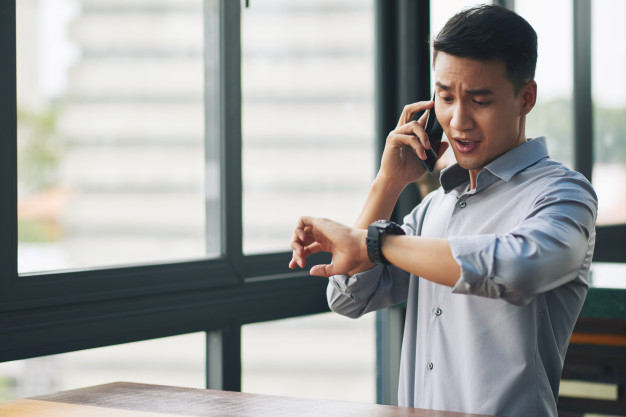 panicking-asian-man-talking-mobile-phone-looking-wristwatch_1098-17413.jpg