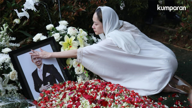 Bunga Citra Lestari memegang foto Ashraf Sinclair di atas makam. Foto: Fanny Kusumawardhani/kumparan