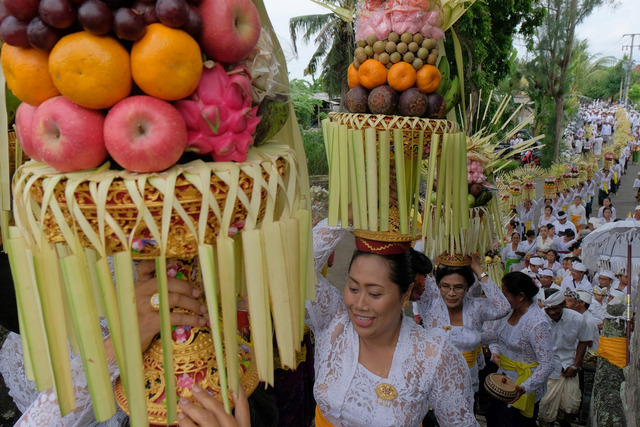 Sejumlah perempuan Bali mengusung sesajen dan hiasan janur dalam tradisi Mapeed yaitu rangkaian persembahyangan Hari Raya Galungan, Bali, Rabu (19/2). Foto: ANTARA FOTO/Nyoman Hendra Wibowo