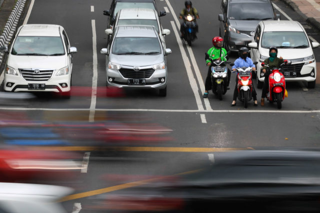 Pengendara kendaraan bermotor berhenti di lampu merah perempatan Jalan Darmo-Jalan Pandegiling, Surabaya, Jawa Timur, Rabu (19/2). Foto: ANTARA FOTO/Didik Suhartono
