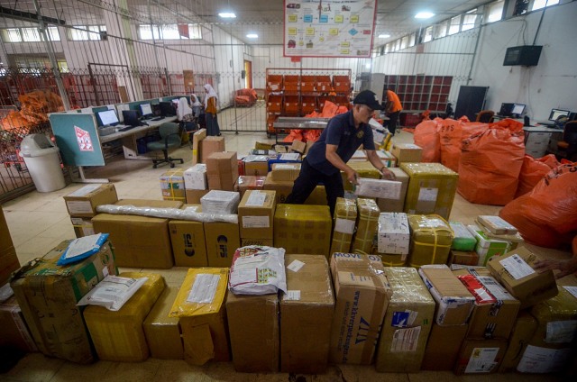 Pekerja memilah paket yang datang dari luar negeri di Sentral Pengolahan Barang PT Pos Indonesia di Bandung, Jawa Barat, Kamis (20/2). Foto: ANTARA FOTO/Raisan Al Farisi