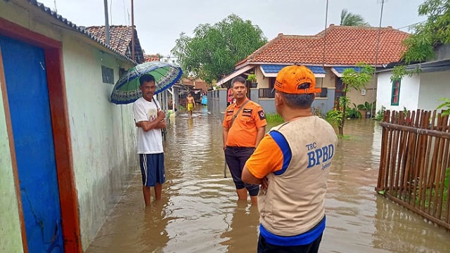 Petugas BPBD Indramayu meninjau permukiman warga yang terendam banjir di Kelurahan Margadadi. (Ciremaitoday)