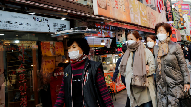Sejumlah warga memakai masker sebagai upaya pencegahan virus corona berjalan di pasar tradisional Seoul, Korea Selatan, Kamis (20/2).  Foto: REUTERS / Heo Ran