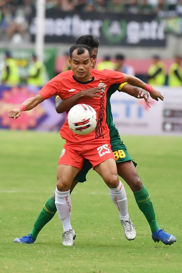 Pemain Persija Jakarta Riko Simanjuntak berebut bola dengan pemain Persebaya pada pertandingan final Piala Gubernur Jatim 2020 di Gelora Delta Sidoarjo. Foto: ANTARA FOTO/Zabur Karuru