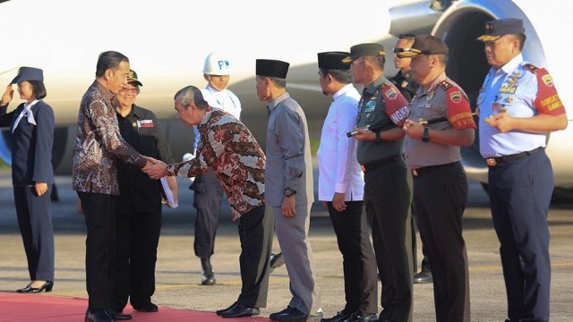 GUBERNUR Riau, Syamsuar, menundukkan badan sambil bersalaman dengan Presiden Joko Widodo, Kamis, 20 Februari 2020, usai mendarat di Lanud Roesmin Nurjadin, Pekanbaru. (Foto: Diskominfi Riau)