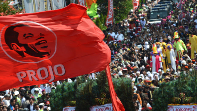 Pendukung Presiden Indonesia, Joko Widodo mengibarkan bendera bertuliskan "PROJO" saat pawai kemenangan di Jakarta, Senin (20/7/2014). Foto: Adek Berry/AFP