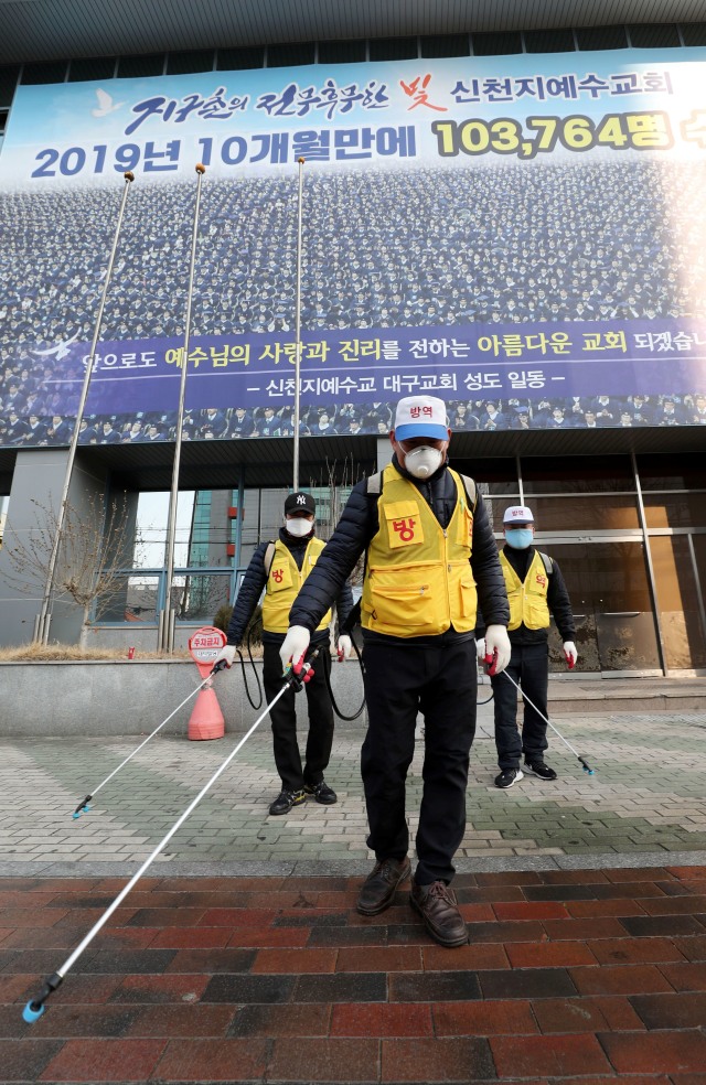 Petugas kesehatan Korea Selatan menyemprotkan cairan disinfektan di Gereja Yesus Shincheonji di Daegu, Korea Selatan, Kamis (20/2).  Foto: AFP/YONHAP