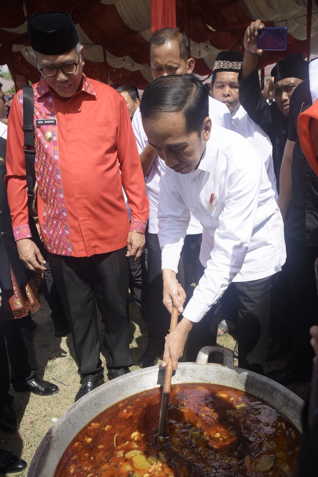 Presiden Joko Widodo saat mengaduk masakan Kuah Beulangong pada acara Kenduri Kebangsaan di Sekolah Sukma Bangsa, Bireuen, Aceh. Foto: Rahmat Mirza