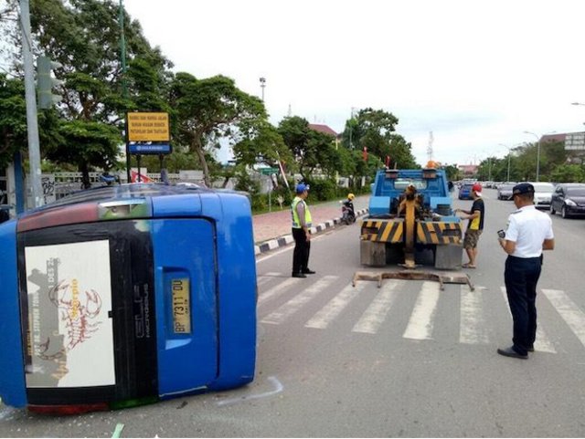 Sebuah angkutan umum bimbar terguling di simpang lampu merah Engku Putri Masjid Raya Batam (Foto: Batamnews)