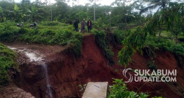 Saluran irigasi aliran Sungai Ciletuh di Kampung Cigombong RT 09/02 Desa Pasirpanjang, Kecamatan Ciracap, Kabupaten Sukabumi jebol akibat hujan deras dan longsor pada Minggu (16/2/2020). | Sumber Foto:Ragil Gilang