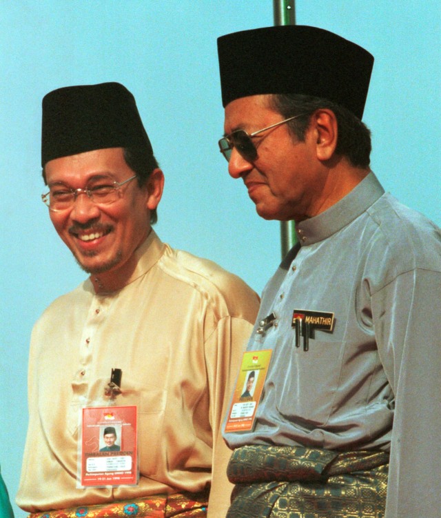 Anwar Ibrahim (kiri), berdiri di sebelah Mahathir Mohamad selama Pertemuan Tahunan UMNO 1998 di Kuala Lumpur. Foto: AP Photo/Vincent Thian