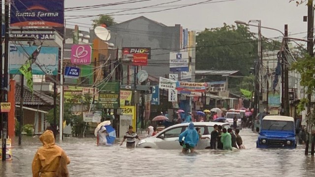Warga beraktivitas saat banjir merendam di depan Perumahan Masnaga, Bintara, Bekasi Barat, Selasa (25/2).  Foto: Dok. Istimewa