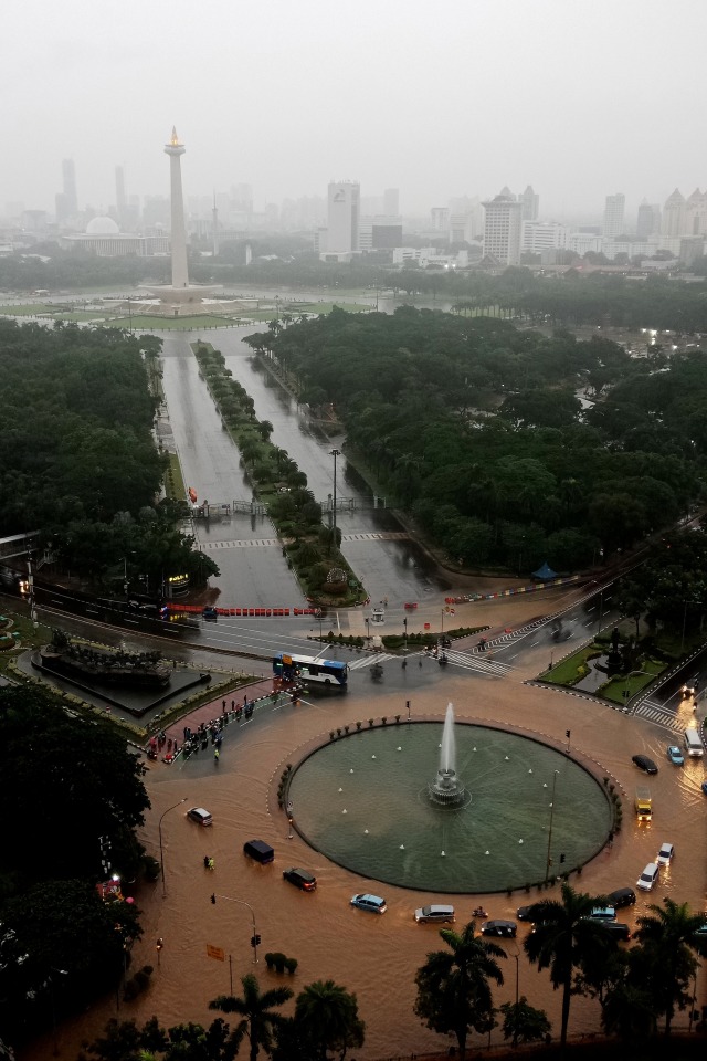 Suasana sejumlah kendaraan melintasi banjir yang menggenangi kawasan Bundaran Bank Indonesia di Jakarta Pusat, Selasa (25/2). Foto: ANTARA FOTO/Winda Wahyu Fariansih