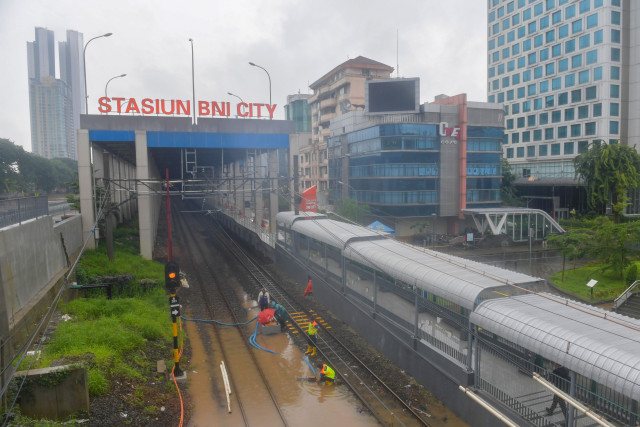 Sejumlah petugas menyedot air dengan pompa yang merendam bantalan rel di Stasiun BNI City, Jakarta, Selasa (25/2). Foto: ANTARA FOTO/M Risyal Hidayat