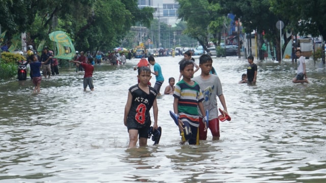Anak-anak bermain saat Banjir Jakarta