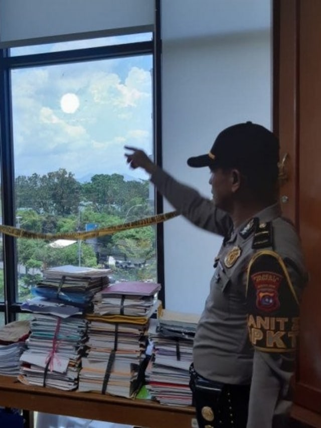 Polisi meunjukkan lubang bekas peluru nyasar yang masuk ke gedung Univeritas Negeri Padang pada Selasa (25/2) Foto: Dok. Istimewa