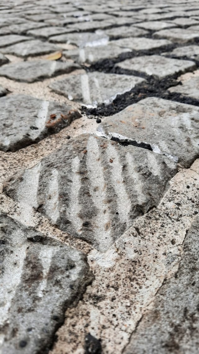 Sisa aspal uji coba lintasan formula e di sela-sela cobblestone monas. Foto: Efira Tamara Thenu/kumparan