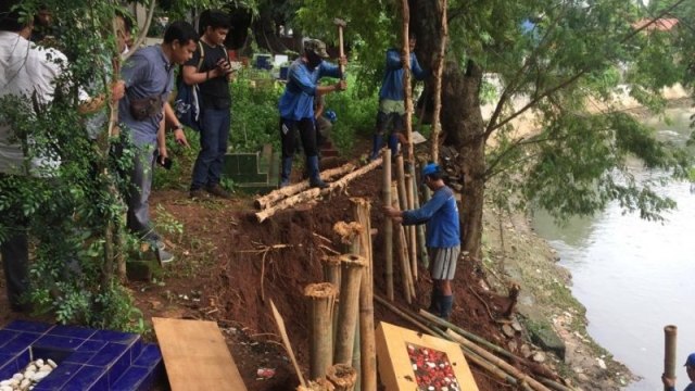 Petugas meperbaiki areal pemakaman keluarga Pangeran Jayakarta,  yang amblas akibat longsor. Foto: ANTARA/Andi Firdaus