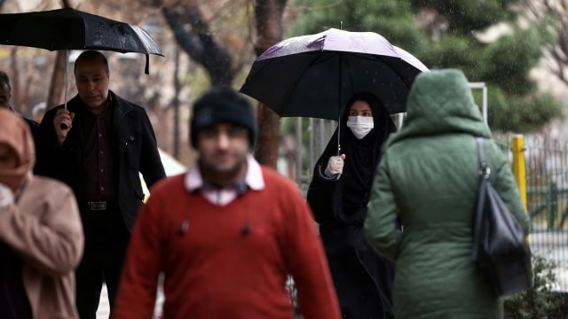 Wanita Iran mengenakan masker untuk mencegah tertularnya virus corona, ketika berjalan di jalan di Teheran, Iran. Foto: WANA/Nazanin Tabatabaee via REUTERS