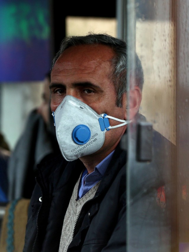 Warga Iran mengenakan masker untuk mencegah tertularnya virus corona, saat beraktivitas di Teheran, Iran. Foto: WANA/Nazanin Tabatabaee via REUTERS