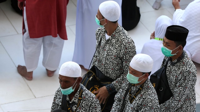 Jemaah Umrah mengenakan masker untuk mencegah tertular virus corona di Masjidil Haram, Mekah, Arab Saudi. Foto: REUTERS/Ganoo Essa