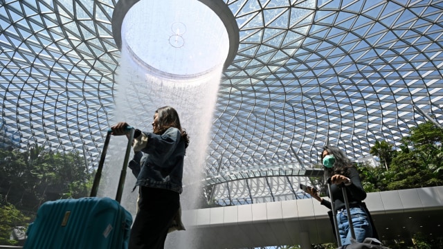 Pengunjung menggunakan masker saat berada di Changi Airport, Singapura. Foto: AFP/Roslan Rahman