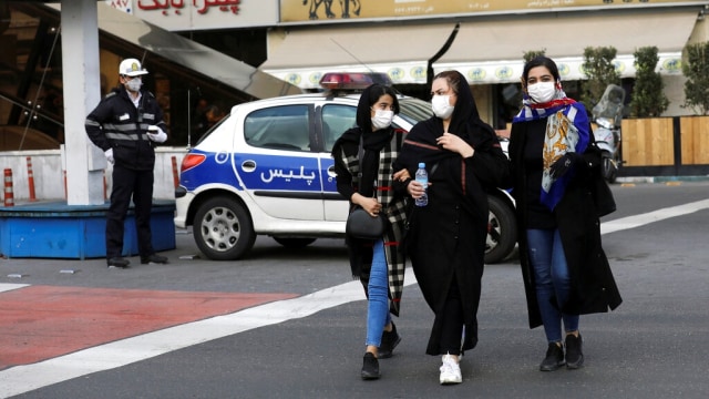 Warga memakai untuk mencegah penyebaran virus corona di sebuah jalan di pusat kota Teheran, Iran. Foto: AP Photo/Ebrahim Noroozi