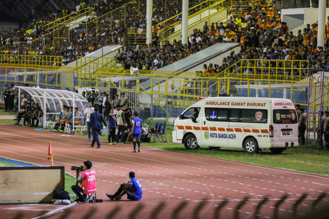 Petugas medis memasukkan ambulans ke dalam Stadion Harapan Bangsa untuk mengevakuasi Agus Suhendra yang mengelami cedera patah tangan pad laga Persiraja vs Bhayankara, Sabtu (29/2) malam. Foto: Abdul Hadi/acehkini