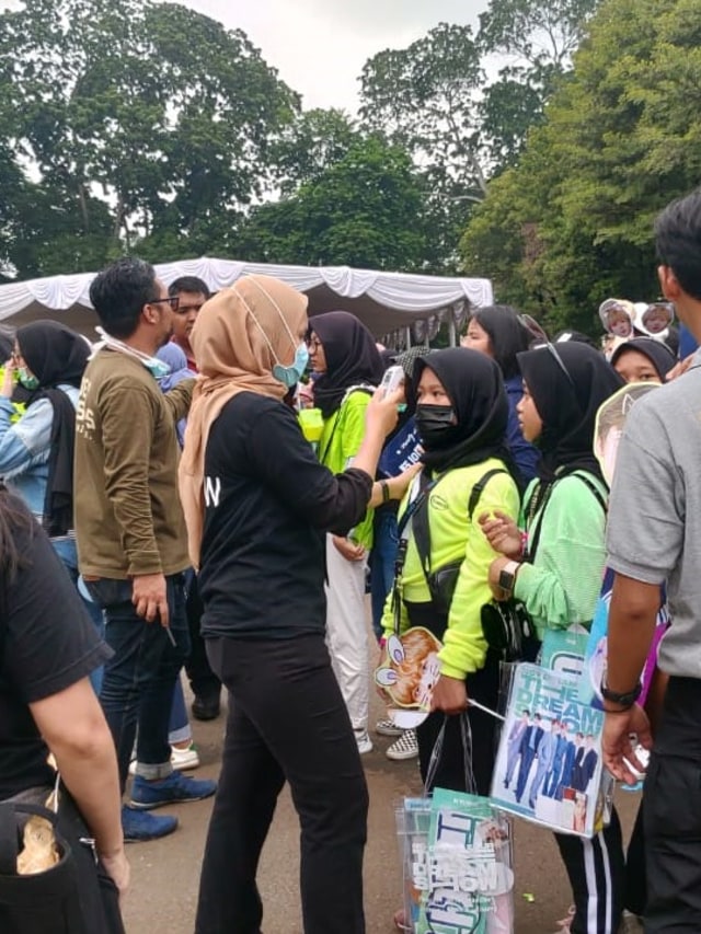 Petugas mengecek suhu badan penonton konser NCT Dream di Jakarta untuk mengantisipasi penyebaran virus corona.
 Foto: Niken Nurani/kumparan