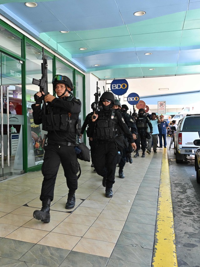 Anggota tim SWAT polisi tiba di lokasi penyanderaan di sebuah mal di pinggiran kota Manila.
 Foto: AFP/TED ALJIBE 