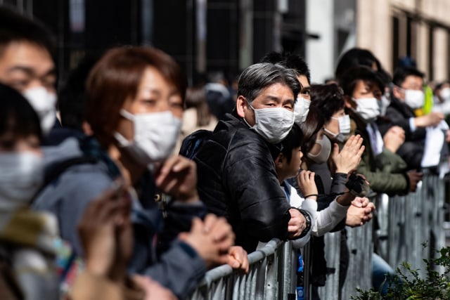 Penonton Tokyo Marathon 2020 menggunakan masker untuk menghindari terkena virus corona. Foto: AFP/PHILIP FONG