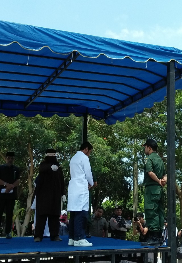 Pria berinisial WM pelaku pelecehan seksual menjalani hukuman cambuk yang digelar di Taman Bustanussalatin, Banda Aceh, Senin (2/3). Foto: Husaini/acehkini