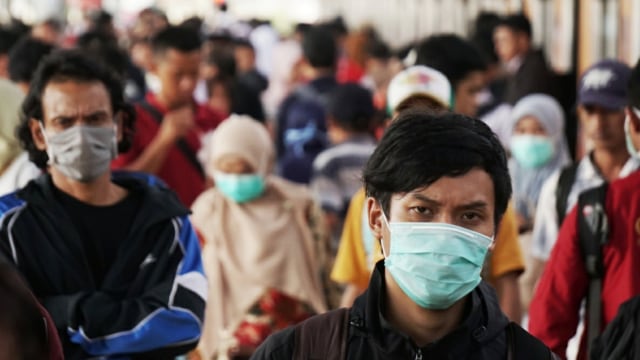 Sejumlah penumpang menggunakan masker berjalan di Stasiun Depok, Depok, Jawa Barat, Senin (2/3). Foto: Jamal Ramadhan/kumparan 
