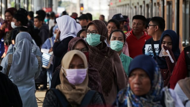 Sejumlahpenumpang menggunakan masker berjalan di Stasiun Depok, Depok, Jawa Barat, Senin (2/3). Foto: Jamal Ramadhan/kumparan