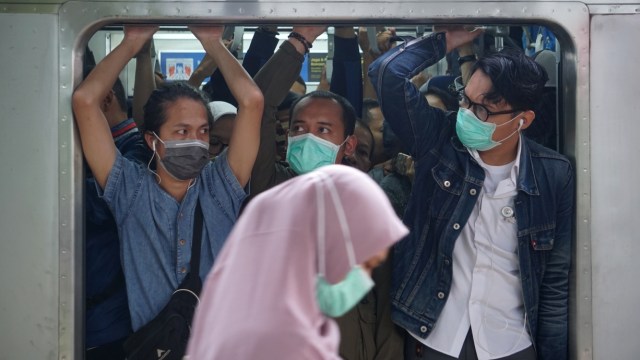 Sejumlah pengguna angkutan kereta rel listrik (KRL) mengenakan masker di dalam gerbong KRL di Stasiun Pasar Minggu, Jakarta.  Foto: Fanny Kusumawardhani/kumparan