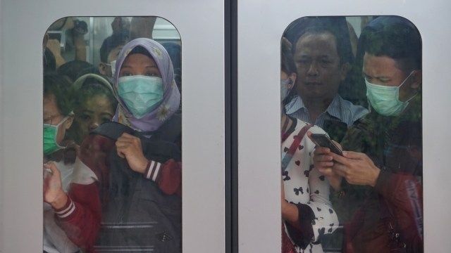 Sejumlah pengguna angkutan kereta rel listrik (KRL) mengenakan masker di dalam gerbong KRL di Stasiun Pasar Minggu, Jakarta, Selasa (3/3).  Foto: Fanny Kusumawardhani/kumparan