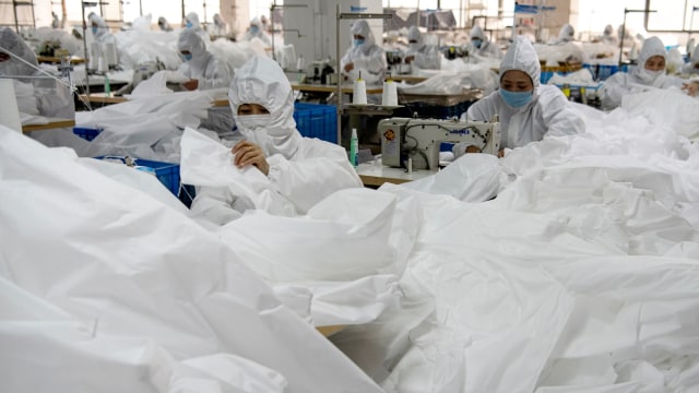 Ilustrasi produksi pembuatan baju hazmat. Foto: AFP/NOEL CELIS