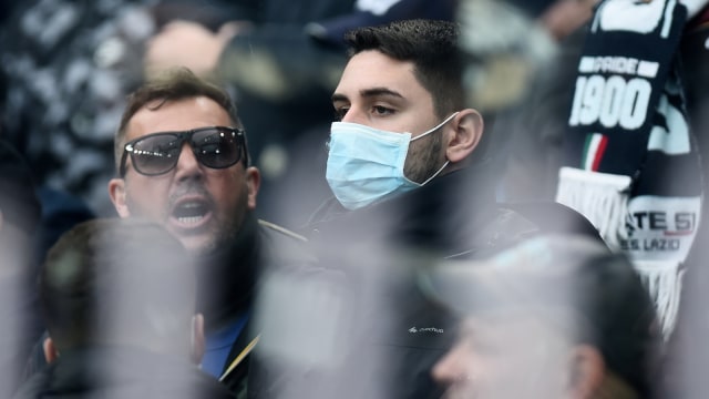 Suporter sepak bola di Italia menonton pertandingan dengan mengenakan masker. Foto: Reuters/Massimo Pinca