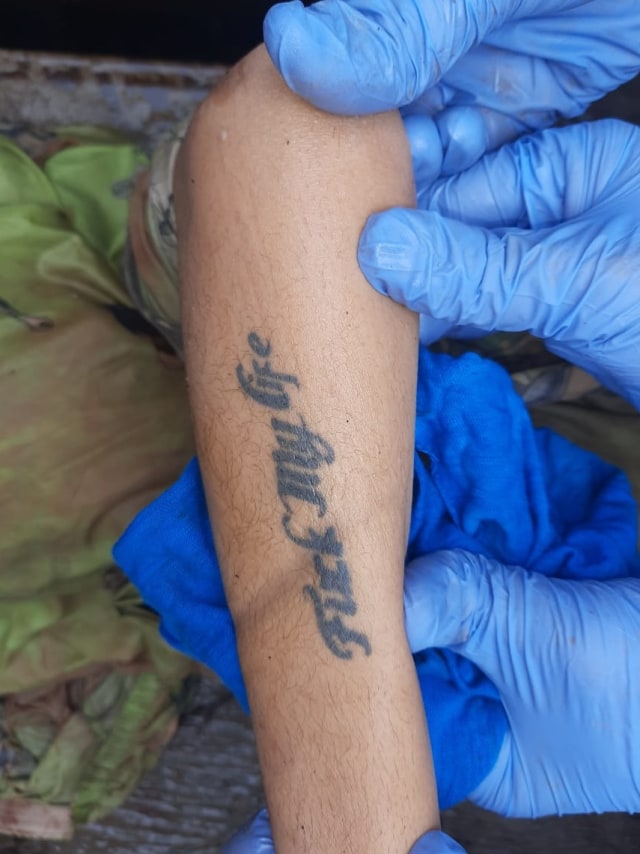 Petugas menunjukkan tato yang di tubuh mayat wanita yang ditemukan di Lembang, Foto: Dok. Istimewa